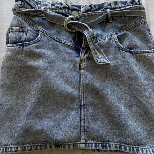 Jeanskjol strl 40  - Oanvänd jeanskjol från hm med fint bältdetalj. Något liten i strl passar nog 38 också.  Nypris 299:- 
