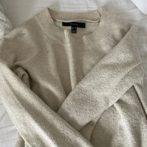 Stickad tröja - En vit/beige stickad tröja från vila. Tröjan är använd och tvättad flertal gånger men har inga skador och är inte sliten. Eftersom den är tvättad är den lite nopprig 