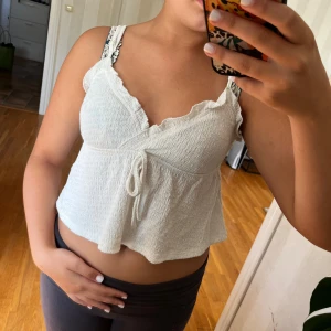 Vit topp från Shein - Säljer en söt vit topp från Shein i storlek S. Toppen är ärmlös och är super fin på. Den är croppad och har en liten knytning framtill. Perfekt för sommaren!