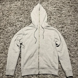 Grå hoodie från Number (N)ine - En grå fullzip hoodie från Number (N)ine. Den har broderat de ikoniska musik noterna och (N) på luvan samt loga både på bröstet och längst ner på baksidan. Den är i bra skick men lite nopprig. Pris går att diskuteras!