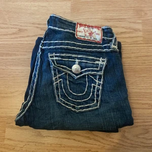 True Religion Jeans  - !skicka bud för snabb affär! Fina true religion jeans, lågmidjade. I mycket fint skick. Mått :                    Midja 34cm Ytterben 97cm Innerben 76 cm  Ben öppning 15,5 cm