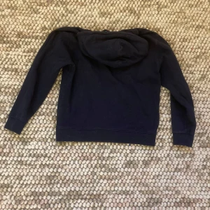 Mörkblå hoodie från Napapijri - Säljer en snygg mörkblå hoodie från Den har en liten logga på bröstet som ger en extra touch.