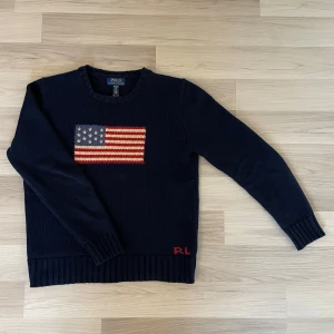 Ralph Lauren Flag Sweater - Säljer denna extremt eftertraktade och snygga tröjan. Tröjan är stickad med den ikoniska flaggan på bröstet som kännetecknar Ralph Lauren. Tröjan är i perfekt skick och använd sparsamt fåtal gånger. Den är XL i barnstorlek vilket sitter som en S eller M. Nypris runt 5-6 tusen. Tröjan är självklart äkta och har en qr kod vid lappen med storlek som bevisar autensiteten genom att ta dig till Ralph Laurens hemsida.