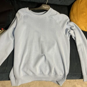 Ljusblå tröja från 157 - Säljer en stilren ljusblå tröja från 157. Tröjan har långa ärmar och ribbade muddar vid ärmslut och nederkant. Perfekt för en avslappnad look.