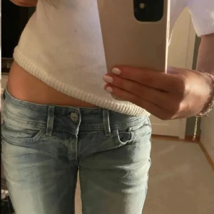 Ljusblå jeans med slitningar - (Lånade bilder!) Snygga ljusblå jeans med slitningar på knäna. De har en låg midja och en straight passform. Skriv vid funderingar🩷