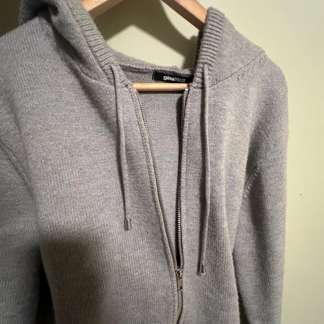 Grå stickad hoodie från Gina 