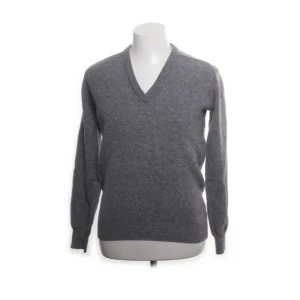 Grå v-ringad tröja från Lyle & Scott - Säljer en stilren grå tröja från Lyle & Scott med v-ringning. Perfekt för en klassisk look. Tröjan har långa ärmar och är tillverkad i ett mjukt material som ger en bekväm passform.