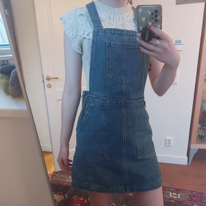 Jeansklänning med hängslen - Säljer den här hängselklänningen med fickor fram och bak. Köpt på Primark för hundra år sen men sparsamt använd. Supersöt och många fickor!