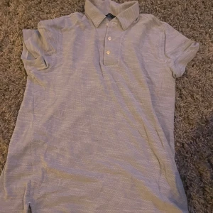 Massimo dutti piké - Säljer en stilren massimo dutti piké med krage och knappar. Perfekt för en avslappnad men ändå snygg look. Kortärmad och i ett mjukt material.