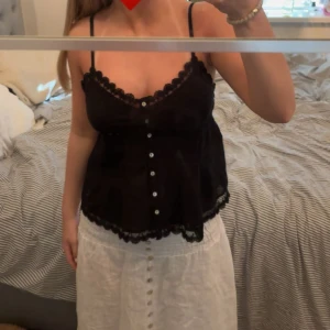 Svart spetslinne med knappar - Säljer ett svart linne som aldrig kommit till användning 