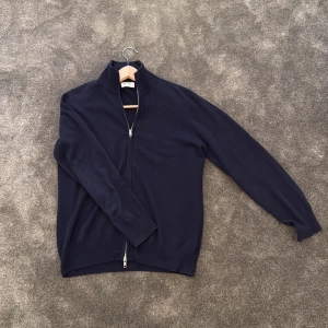 Mörkblå kashmirtröja från Soft Goat - Säljer en elegant mörkblå kashmirtröja från Soft Goat med dragkedja framtill. Snabb affär = bättre pris