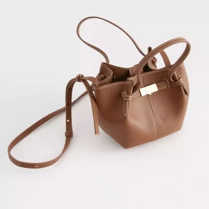 Brun axelväska med gulddetalj - Snygg brun axelväska med justerbar axelrem och gulddetalj framtill. Såldes slut samma dag den kom till butiken, HELT SLUTSÅLD, ONLINE OCH I BUTIK! 