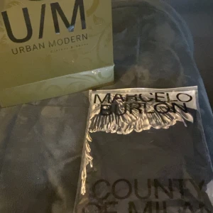 Svart t-shirt med vingmönster från Marcelo Burlon - Säljer en svart t-shirt från Marcelo Burlon med ett coolt vingmönster runt halsen. Perfekt för dig som vill ha en unik och stilren look. T-shirten är kortärmad och gjord i mjukt material. Helt oanvänd köpt för 3200 kvitto dust bag o påsen kmr med 
