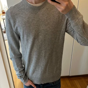 Grå ulltröja från Filippa K - Säljer en stilren grå tröja från Filippa K i ullblandning. Tröjan har långa ärmar och en rund halsringning, perfekt för kyligare dagar. Enkel och tidlös design som passar till det mesta. Storlek S. Hör gärna av vid frågor, funderingar eller prisförslag:)