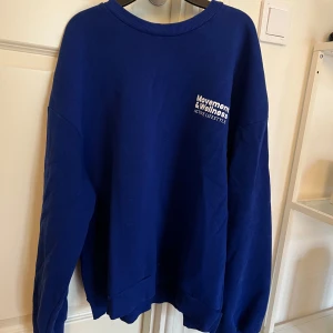 Blå sweatshirt från Gina Tricot - Säljer en blå sweatshirt från Gina Tricot med trycket 'Movement & Wellness Active Lifestyle' på bröstet och ryggen. Tröjan har en rund halsringning och långa ärmar. Perfekt för en avslappnad stil. 