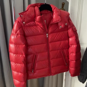 Moncler Jacka 14y röd - Moncler jacka i size 14y (motsvarar 32, 34) i rött.  Superfint skick. Säljes för 4500 sek (nypris 9370 sek). 