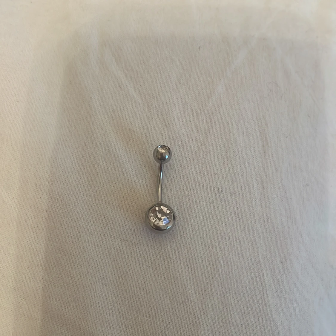 Silverfärgad navelpiercing med kristaller