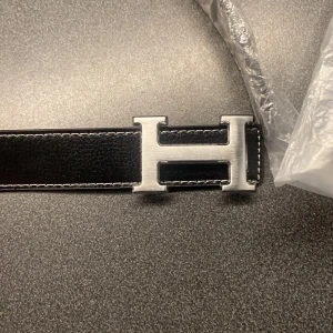 bälte - Ett fint H bälte i 105cm som är helt nytt och det ingår ett pärlarmband