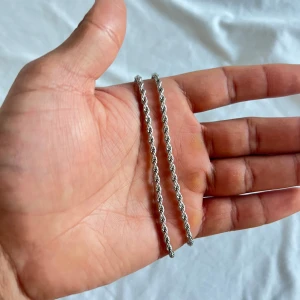 Rostfri silver chain Vintage - Elegant silverfärgat halsband med en tvinnad kedja som ger en stilren och tidlös look. Perfekt för att komplettera din outfit med en subtil glans. Kedjan har en enkel låsning som gör det lätt att ta på och av.