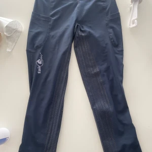 Mörkblåa ridbyxor - Snygga mörkblåa ridbyxor från Fair Play i storlek XS. Byxorna är stretchiga och ganska tunna perfekt till sommaren. De har praktiska fickor och ett mönster längs benen för extra grepp. Perfekta för ridning. Skriv för fler bilder eller mått💕Använda ett par gånger men inget som syns!!