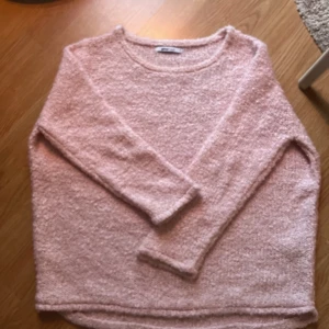 Rosa stickad tröja från Gina Tricot - Mysig rosa stickad tröja från Gina Tricot. Perfekt för kyliga dagar med sin fluffiga textur och långa ärmar. Enkelt och stilrent designad för att passa till många olika outfits.