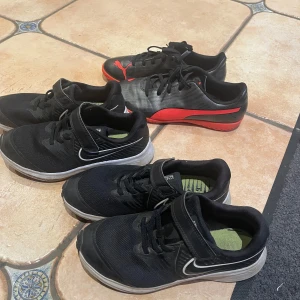 Svarta och röda fotbollsskor från Puma och Nike - Säljer ett par svarta och röda Puma fotbollsskor med snörning och ett par svarta Nike sneakers med kardborreband. Perfekta för sport och träning.Varje en skor  kostar 100 kr, men om du tar alla tre skor  blir det 250 kr.