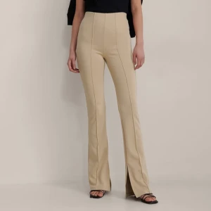 Beige kostymbyxor - Eleganta beige kostymbyxor med hög midja och bootcut-stil. Byxorna har en stilren design som passar perfekt för en chic look. De är tillverkade i ett mjukt och bekvämt material som ger en snygg siluett. Skriv för att se bild på de byxor jag säljer. 