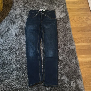 Mörkblå jeans från Levi's - Snygga mörkblå Levi's jeans med klassisk design och fem fickor. De har en rak passform och är perfekta för en avslappnad stil. Märketiketten på baksidan ger en autentisk touch.