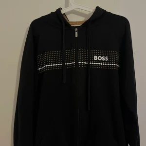 Svart kofta från Boss - Snygg svart hoodie från Boss, Använt ett par gånger. Priset går o diskutera. Passar även som M 