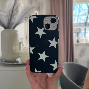 Svart mobilskal med vita stjärnor - Snyggt svart mobilskal med vita stjärnor. Perfekt för att ge din telefon en cool look samtidigt som den skyddas. Aldrig använt. Kommer från SHEIN men det är jätte bra skick på de! De är i iPhone 13 mini. De kostade 25 kr när jag köpte de. Jätte fin 😍