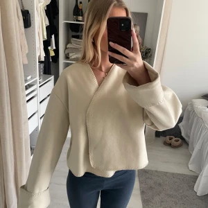 Beige omlottkofta/kappa - Säljer en stilren beige omlottkofta/kappa med långa ärmar, jättebra skick perfekt i sommar!