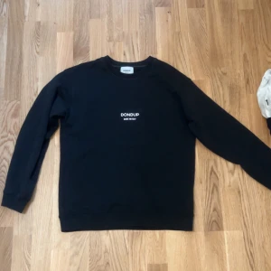 Svart tröja från Dondup - Säljer en stilren svart tröja från Dondup med rund hals och långa ärmar. Perfekt för en avslappnad look. Tillverkad i Italien. 