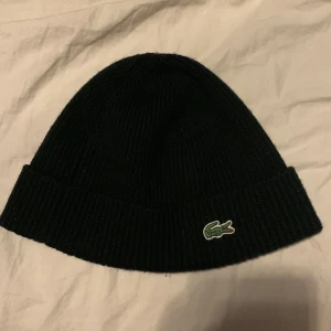 Lacoste mössa - Äkta Lacoste mössa, 10/10 skick, ny pris 799kr. Jag säljer den här mössan för jag använder inte mössa längre.