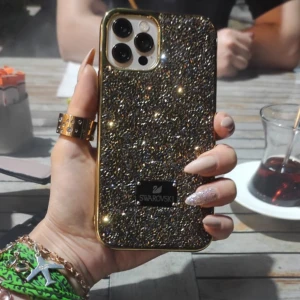 Mobilskal - Säljer min gamla mobilskal från Swarovski 50kr. Material i gummi/plast med glittrande små stenar. För iPhone 12 PRO 