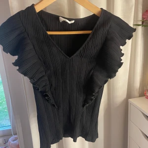 T-shirt - T-shirt från Mango med volang