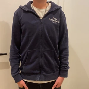  Peak Performance zip hoodie  - Säljer denna snygga mörkblå zip-hoodie från Peak performance. Tröjan har en broderad logga på bröstet och perfekt nu till vintern. Tröjan är använd en del men fortfarande perfekt skick. Riktigt skön och lätt att stila. Storlek 160cm = xxs vuxenstorlek. Kan gå ner i pris vid snabb affär.