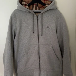 Burberry kofta - Säljer nu en grå burberry kofta, skick är som nytt!  Har tagit väl hand om den, vid en smidig affär kan pris diskuteras!