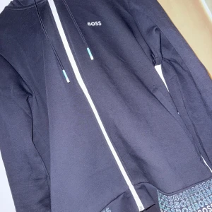Hugo boss zip hoodie - Säljer min äkta Hugo boss hoodie då den är för stor för mig. Har använt den ca 3 gånger. Skicket är som nytt. Pris kan diskuteras vid snabb affär