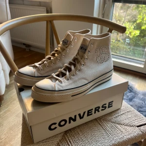 Converse Chuck Taylor All Star 70 HiStussy Fossil Pearl - ”Converse Chuck Taylor All Star 70 Hi Stussy Fossil Pearl”  Skorna är i perfekt skick! Aldrig använda. Men tillkommer låda i perfekt skick, tillkommer även extra snören i svart samt klistermärken. Skorna är självklart äkta.