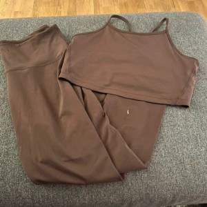 Brun ärmlös linnetopp - Säljer en snygg brun ärmlös linnetopp med smala axelband. Perfekt för träning eller en avslappnad dag. Toppen är i ett mjukt och stretchigt material som ger en bekväm passform.