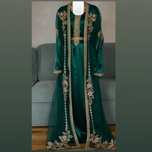 Klänning/ marockans kaftan  - Helt ny och oanvänd. Jätte fin färg och passar upp till storlek 42. Personen har storlek 36 i bilden. Har bälte och kan anpassas till midjan. 