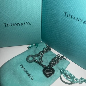Full Heart Toggle Pendant från Tiffany & Co. - Säljer ett elegant halsband från Tiffany & Co. med ett hjärtformat hänge i sterling silver. Halsbandet har en toggle-låsning och är perfekt för både vardag och fest. Kommer med originalförpackning och putsduk. En tidlös klassiker för smyckesamlingen! 💙