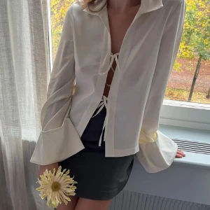 Vit blus från Djerf Avenue - Säljer en superfin vit blus från Djerf Avenue i storlek S. Den har långa ärmar och snygga knytband framtill. Perfekt för både vardag och fest🧡Säljer då den tyvärr inte kommer till användning längre. 