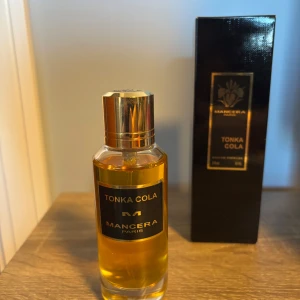 Tonka Cola från Mancera - Säljer en flaska Tonka Cola från Mancera. Den har en elegant, genomskinlig flaska med guldlock och svart etikett. Doften är unik och spännande, perfekt för dig som vill sticka ut. Kommer i originalförpackning. Perfekt för både vardag och fest! 