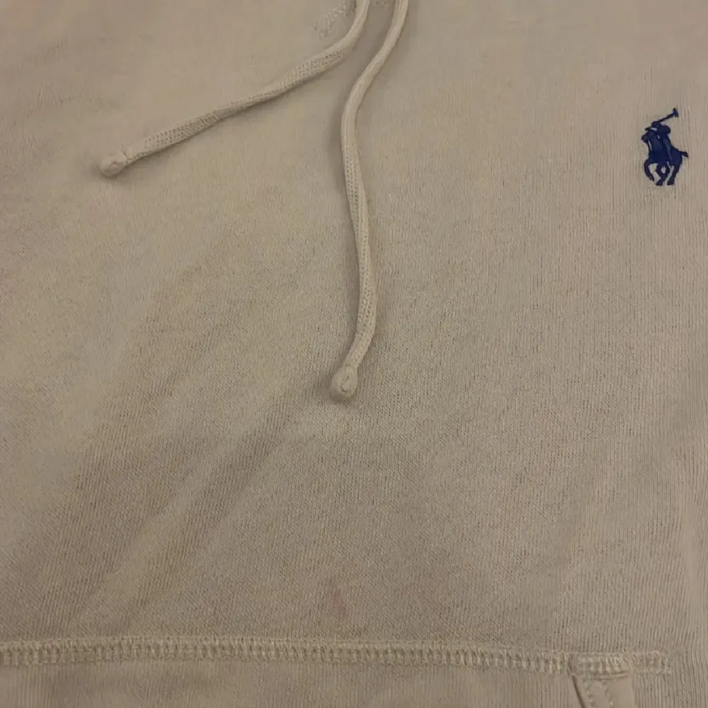 Säljer en stilren vit hoodie från Ralph Lauren med den klassiska loggan broderad i blått på bröstet. Den är i bra skicka förutom att den har en liten rosa fläck men ingen ser det ändå.           Hör av er vid frågor.. T-shirts.