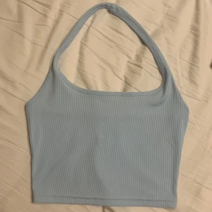 Ljusblå topp halterneck  - Linne som går runt halsen. Ljusblå och endast använd en gång så är i fint skick. 