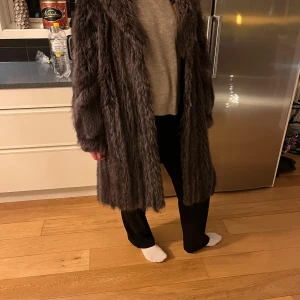 Brun pälsjacka - Säljer en supermysig brun pälsjacka i mycket bra skick. Den är perfekt för kalla vinterdagar och har en klassisk långärmad design. Jackan är i en normal passform och ger en lyxig känsla. Perfekt för att hålla sig varm och stilren under vintern!