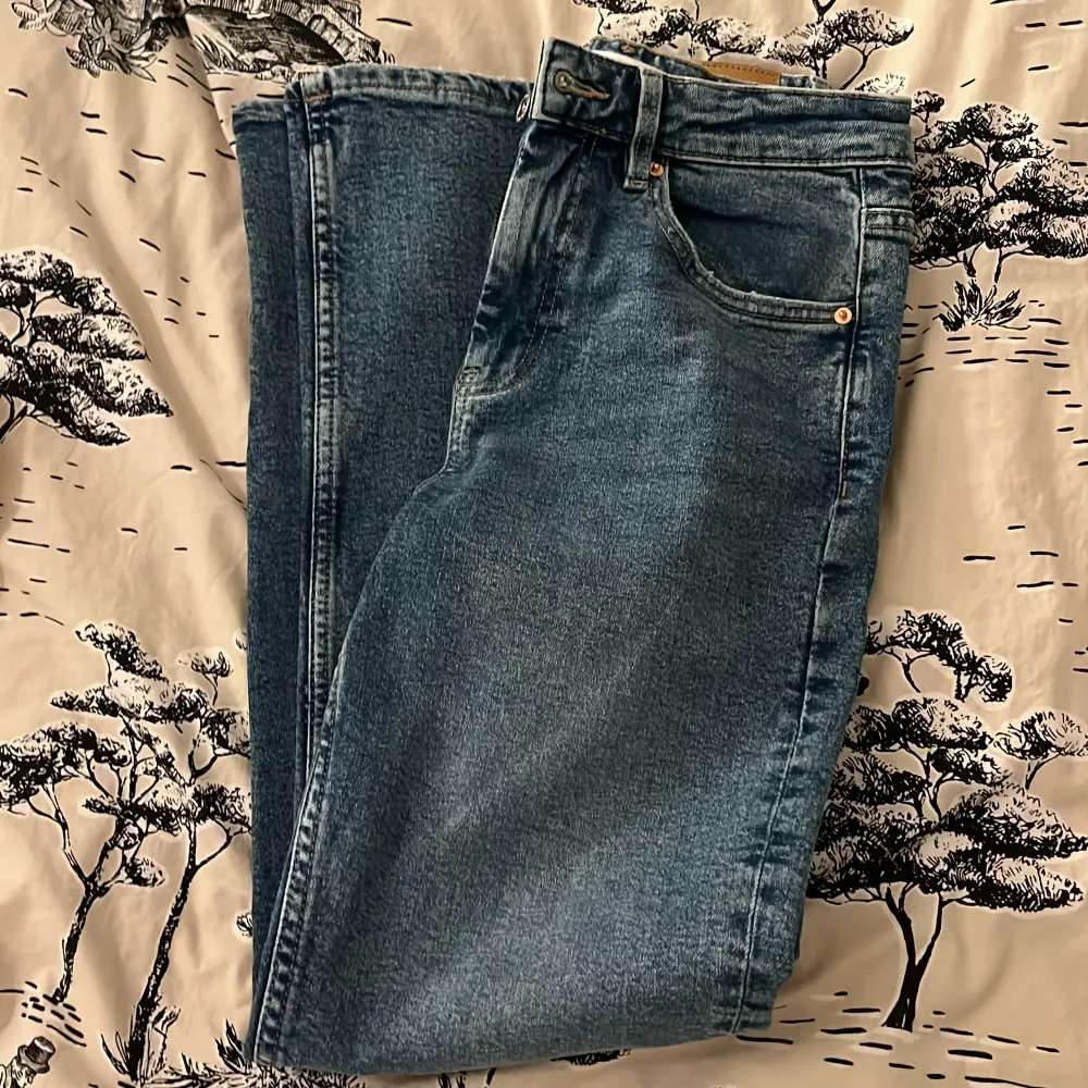 Säljer ett par klassiska blå jeans från Gina Tricot i storlek 34. De har en snygg straight passform och är i mycket bra skick. Perfekta för både vardag och fest! 👖✨. Jeans & Byxor.