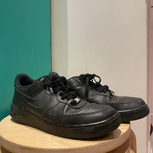 Svarta Nike Air Force sneakers - Säljer ett par klassiska svarta Nike Air Force sneakers i använt skick. Pris kan diskuteras. Skolåda ingår inte. 