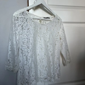 Vit spetsblus med trekvartsärm - Säljer en superfin vit spetsblus med trekvartsärm. Perfekt för både vardag och fest! Blusen har en elegant och luftig design med vackra spetsdetaljer. Passar perfekt till sommarens alla tillfällen. 🕊️